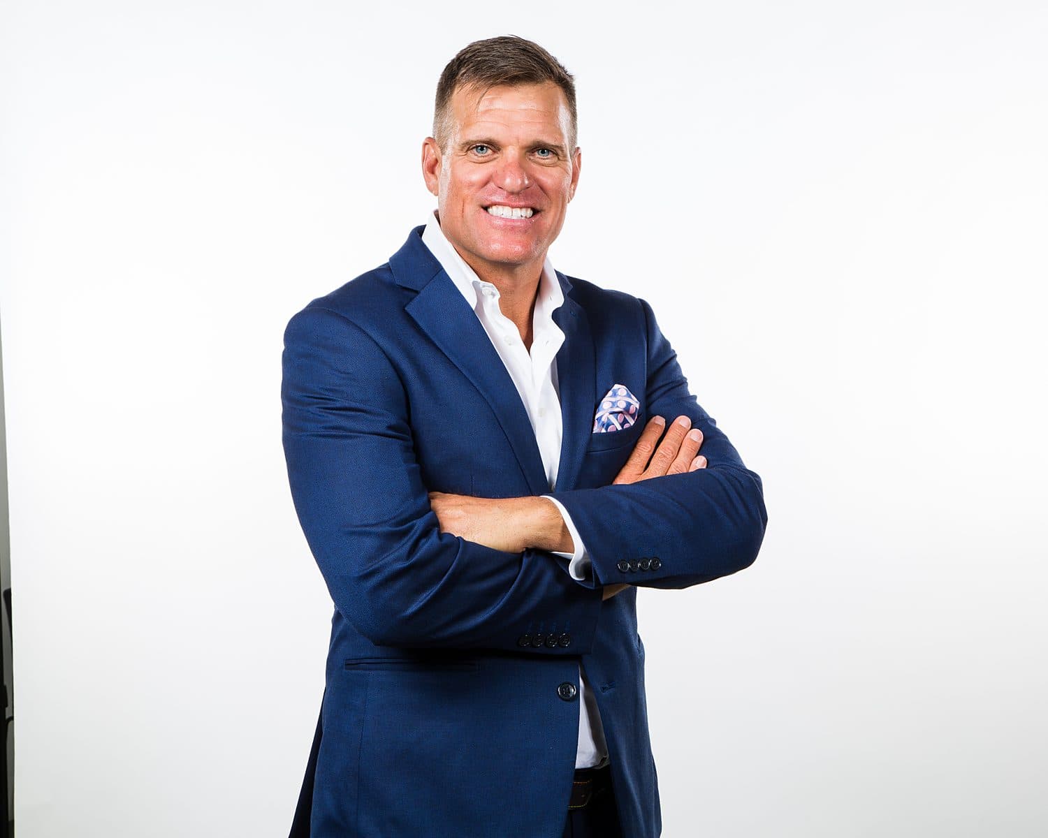 Dave VanHoose in a navy suit with arms crossed: authority